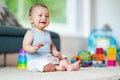 Cute smiling baby boy sitting on floor in living room Royalty Free Stock Photo