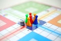 Picture of Dice and different colors tokens on the center ludo game