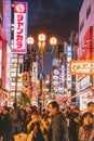 A picture of Dotonbori at night, filled with people and signs advertising shops.