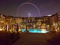 Picture of Dubai Caesar Palace hotel from the pool side with the Bluewaters ferris wheel in background. Hotel design background.