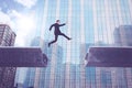 European businessman jumping over bridge gap