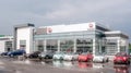 Picture of Fiat dealer salon with cars outside of it. There are cars with different colors of body. It is cloudy outide