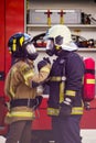 Picture of firefighters women and men in helmet and mask looking at each other and doing handshake near fire truck Royalty Free Stock Photo