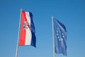 Croatian and European flags waiving in the air with a blue sky background. Croatia is youngest country that joined European Union