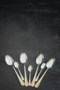 Four beautiful large silver spoons and three small spoons for desserts on a black background Royalty Free Stock Photo