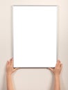 Picture frame of hand is hanging on the wall. woman hanging blank posteron wall. diploma mockup