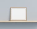 Picture frame mock up on wooden shelf against pastel painted wall. 3D render.