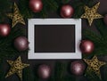 Picture frame and pink christmas baubles composition on brown background. Flat lay. Modern New year decoration photo frame