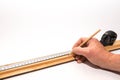 Picture framer, carpenter marking a long piece of picture frame with a pencil