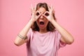 Funny young woman gesturing with fingers and looking camera. Royalty Free Stock Photo