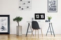 Picture gallery and a concrete planter in a simple home office interior for a freelancer professional with a computer screen mock-