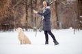 Picture of girl in black jacket training dog in snowy park Royalty Free Stock Photo