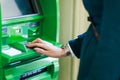 Picture of girl in coat at green cash machine Royalty Free Stock Photo
