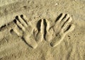 Drawing of the hands on the sand.