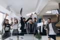 Picture of happy business team celebrating victory in office. Successful business team throws pieces of paper in modern office Royalty Free Stock Photo