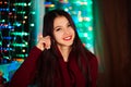 Picture of happy cheerful beautiful girl whit pretty white smile in studio with Christmas lights. Pretty smiling girl on colorful Royalty Free Stock Photo