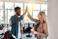 Picture of happy colleagues business team standing in office. Looking aside gives a high-five to each other Royalty Free Stock Photo