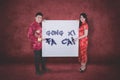 Happy couple showing text of Gong Xi Fa Cai Royalty Free Stock Photo