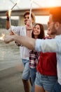 Picture of happy friends holding burning sparkles