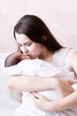 Mother with newborn baby over white. Mom kisses newborn Royalty Free Stock Photo