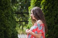 Picture of happy pregnant woman posing isolated over grey wall. Looking at camera and pointing