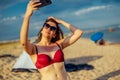 Beautiful woman in swimwear making selfie on a beach Royalty Free Stock Photo