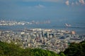 High view angle picture of Kobe cityscape crowded with houses and buildings with seashore and oil refinery industry