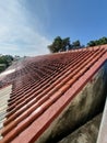 A picture of a house roof that is starting to blacken is taken from a house roof on a sunny day