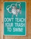 Humorous sign admonishing not to throw trash in the lake.