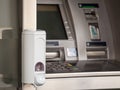 Hand sanitizer dispenser mounted on an ATM distributing cash money in fron of a bank, full of disinfecting hydroalcoholic gel