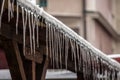 Icicles forming ice stalactites falling fron the edge of the eaves of gutters and roofs of a residential building during a cold Royalty Free Stock Photo