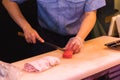 Japanese cook cutting tuna fish at a stall of the Tsukiji Market in Tokyo