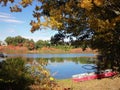 Lakeside Autumn Woods with Old Red Kayak Royalty Free Stock Photo