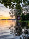 Picture of Lakeside Sunset with trees, scandinavian wooden house and blue sky