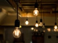 Vintage incandescence lightbulbs, with their iconic filament, hanging on the roof inside a hipsterish industrial room