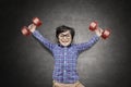 Happy little boy lifting two dumbbells Royalty Free Stock Photo