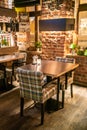 Loft style bar interior with brown wooden tables and checkered chairs at night Royalty Free Stock Photo