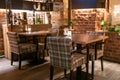 Loft style bar interior with brown wooden tables and checkered chairs at night Royalty Free Stock Photo