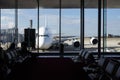 Long range airliner plane waiting in front of an airport seen from the interior of the terminal, from a waiting room Royalty Free Stock Photo
