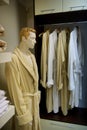A picture of a lot of dressing gowns on wooden hangers in a store and a male mannequin in a dressing gown next to it Royalty Free Stock Photo