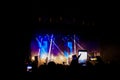 Picture of a lot of people enjoying night perfomance, large unrecognizable crowd dancing with raised up hands and mobile phones on Royalty Free Stock Photo