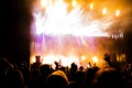 Picture of a lot of people enjoying night perfomance, large unrecognizable crowd dancing with raised up hands and mobile phones on Royalty Free Stock Photo