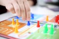 Picture of ludo board game with hand playing ludo