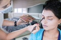 Makeup artist applies brush to her client eyes