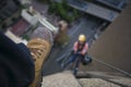 Picture of male leg setting on the edge of building site wearing blue pant, steel cape working safety boot with blurring construct