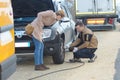 Picture male mechanic replacing clients car tire