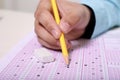 Picture of man hand is filling OMR sheet with pencil. Portrait of eraser on the OMR sheet Royalty Free Stock Photo
