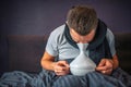 Picture of man using inhaler for treatment and for getting better. He is sick and ill. Guy holds white thing careful and Royalty Free Stock Photo