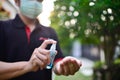 Picture of a man wearing a face mask, holding a bottle of alcohol.