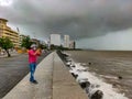 A picture of Marine Drive where a man wearing mask taking photos of the seaside in the rainy day during the lockdown in Mumbai. Royalty Free Stock Photo